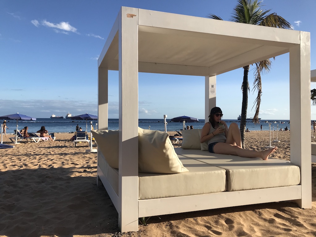 Young woman lying on the leather beach bed in Las Playas de Teresitas in Tenerife